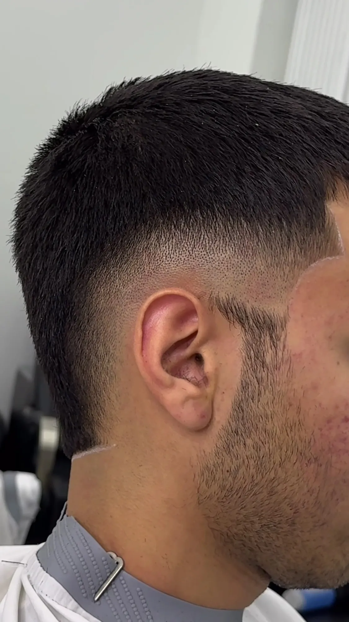 Seitenansicht eines frischen Skin Fade mit sauberer Bart- und Nackenkontur